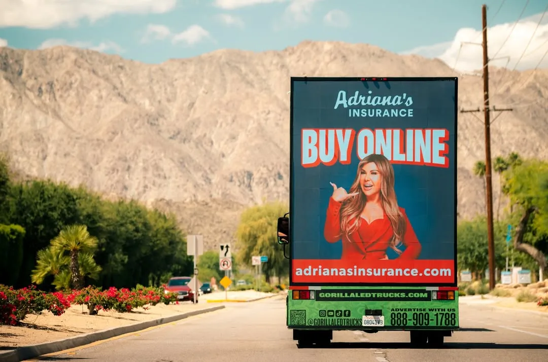An Adriana's Insurance "Buy online" billboard by a desert road